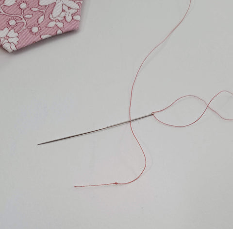 Photo of threaded needle with aurifil 50wt thread, knotted