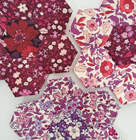 three completed english paper pieced hexagon flowers