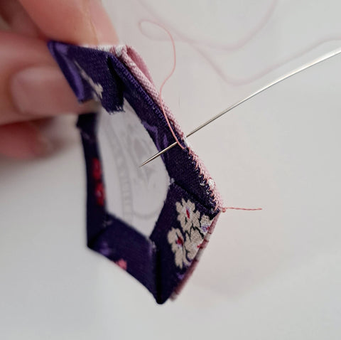 image of a needle whip stitching two hexagons together