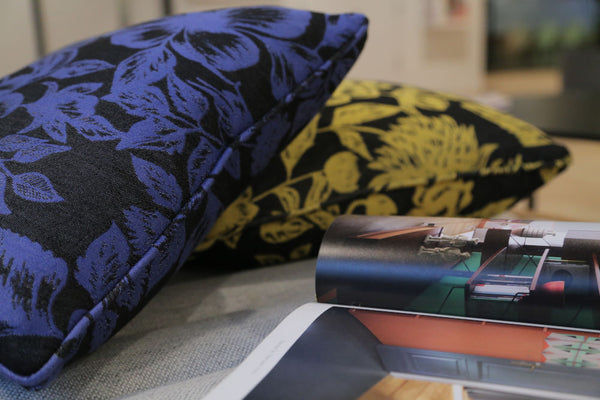 Shaku upcycled Italian silk scarf cushions beside a magazine