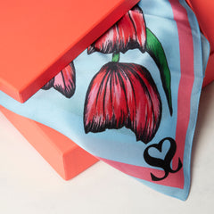 Floral scarf overhanging from coral gift box