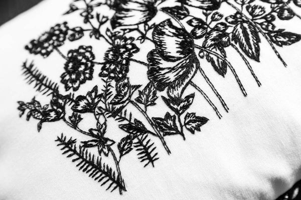 Details of embroidery on white embroidered cushion