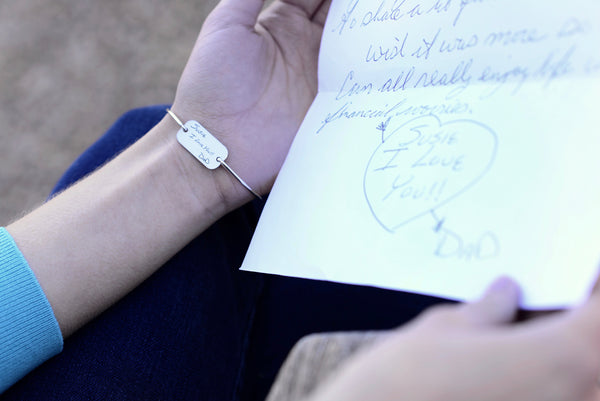 Woman wearing personalized bracelet engraved with handwriting.