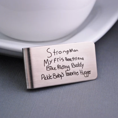 Parent nicknames written in child’s handwriting engraved on money clip made of stainless steel.