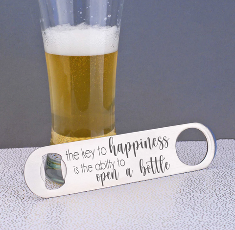 Key to happiness bottle opener with a beer in the background