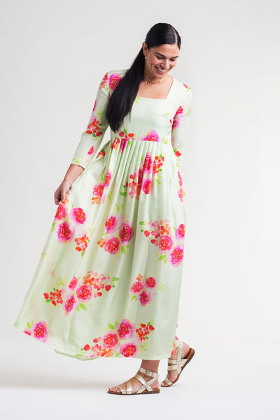 Woman wearing a mint green color silk maxi dress with watercolor floral print