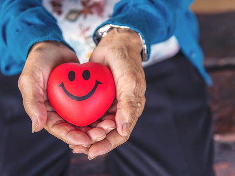 elderly woman holding smiling heart