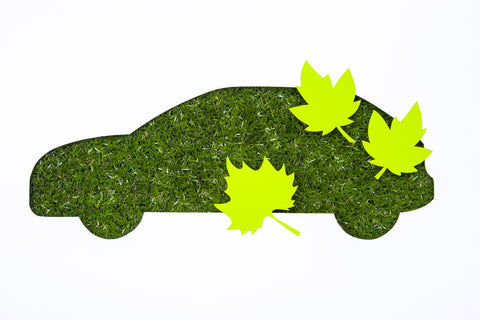 Graphic showing a car made from a grass background and 3 green graphic leaves placed over it