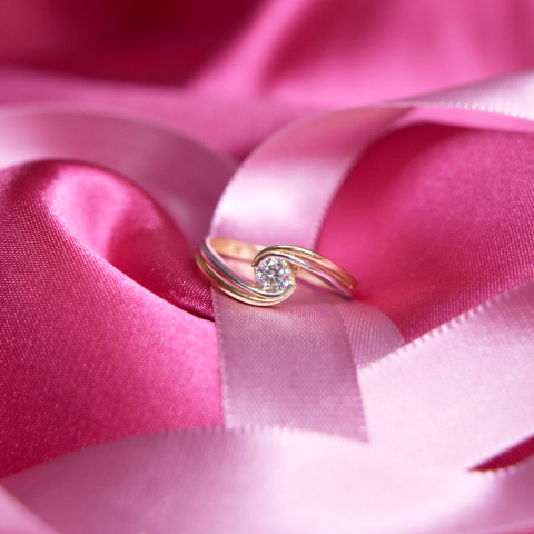 Anillos de compromiso precios; Delicado anillo con diseño entrelazado sobre listón de color rosa