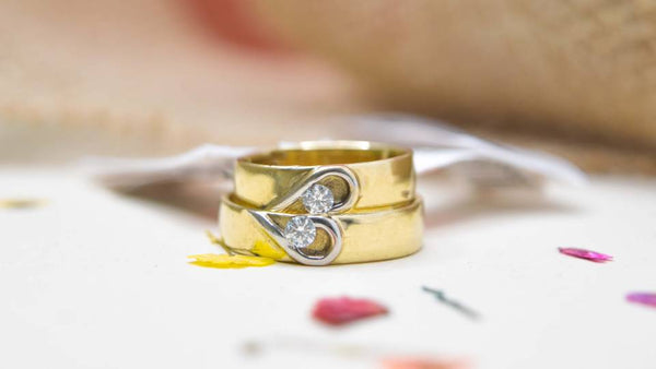Argollas de matrimonio para parejas, de oro amarillo, con corazon de oro blanco complementario.