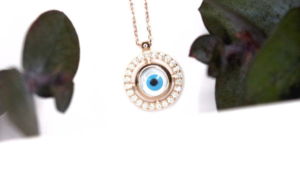 Dije con diamante de diferentes diseños, collar de oro amarillo, con ojo turco al centro de diferentes piedras de diamante.