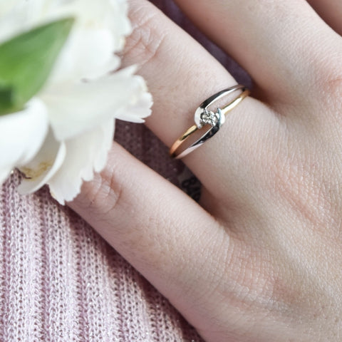 En qué mano va el anillo de compromiso; mujer mostrando un anillo de doble correa en oro amarillo y que abraza una zirconia pequeña