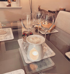 white wax melter on dinning table with wine glasses and four cubes of soy wax