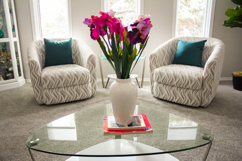 two grey accent chairs with pink flowers on a coffee table