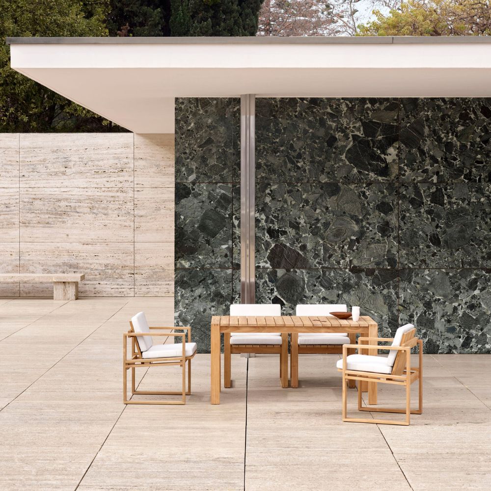 carl-hansen-bodil-kjaer-teak-dining-table-and-chairs-outdoors-by-verdi-alpi-marble-wall-danish-summer-house.jpg__PID:0c894a91-dbeb-49b0-ade9-113ee708667b