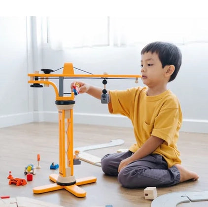 Boy playing with Plan Toys Crane Set