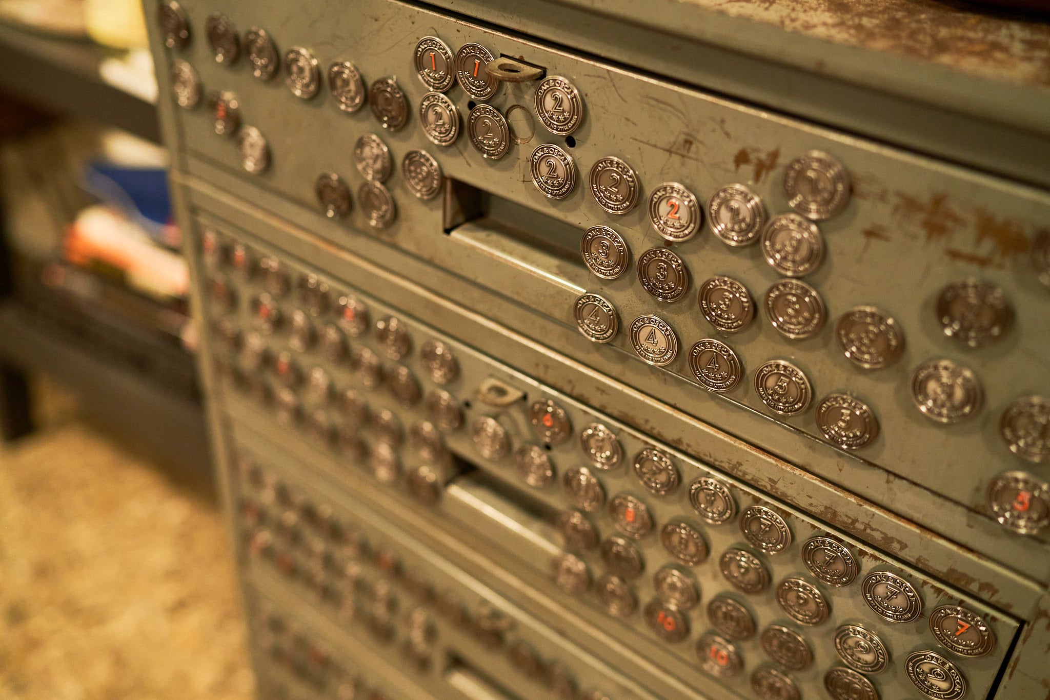 Image of magnetic lapel pins with numbers on a steel cabinet