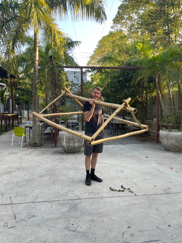 James Mann holding the structure he built out of Miami native bamboo for the Berber Svenska Tent