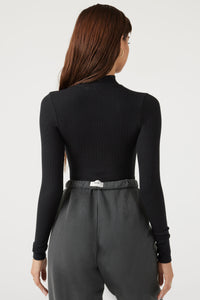 Back view of model posing in the fitted stretchy black rib Half Zip Mock Neck long sleeve top with a mock neckline