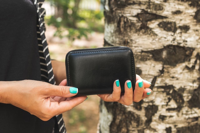 woman holding small leather wallet_ The Guilty Woman