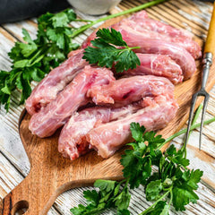 Chicken necks stacked on an elegant cutting board with garnish