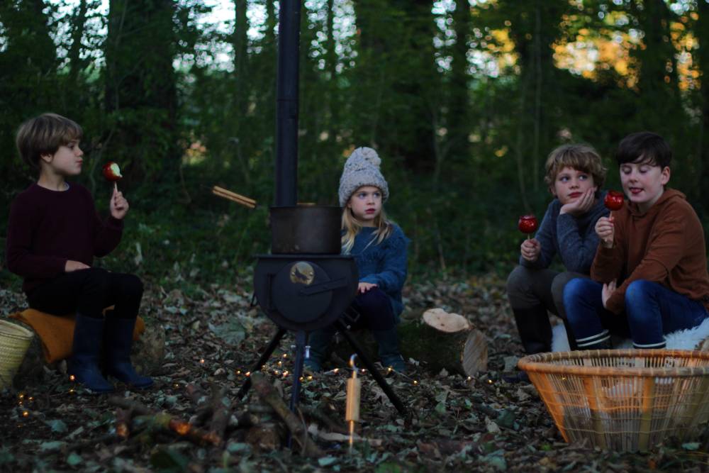 Children eating toffee apples sat around Anevay Frontier wood burning stove