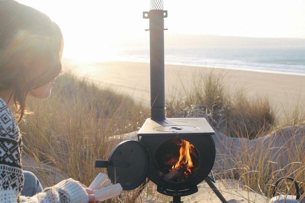 The Girl Outdoors cooking outdoors on an Anevay portable woodburning stove
