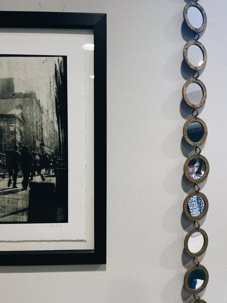 A corner of the MoMuse workshop featuring a photographic print and a decorative mirror