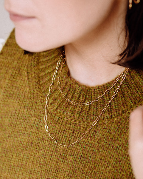 A girl wearing a layered gold filled paperclip necklace.