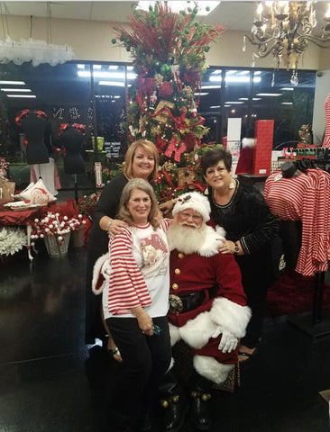 Queen Bling employees hanging out with Santa at a boutique holiday event. 