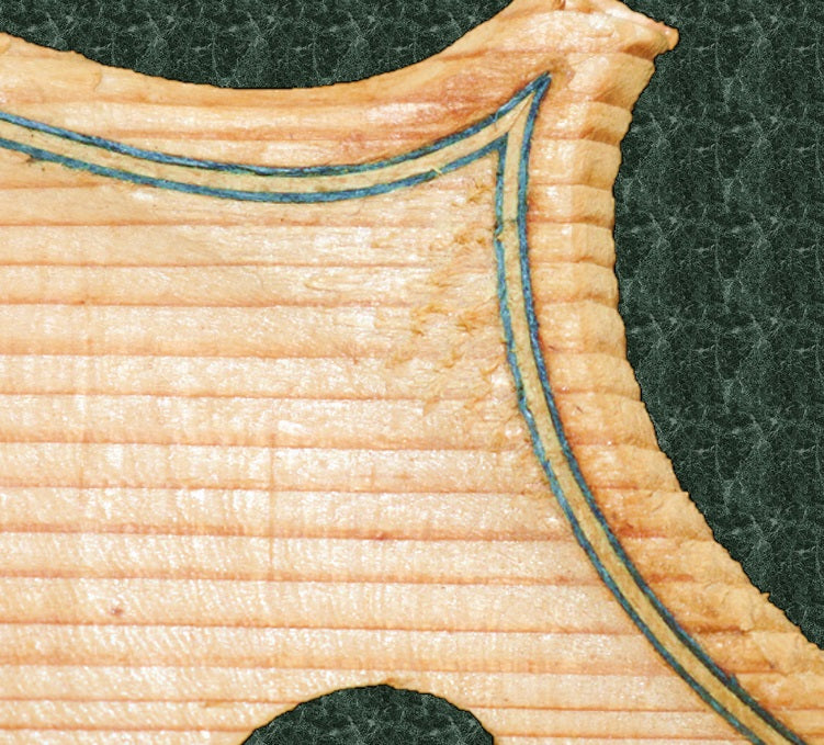 This image shows inlaid purfling on an unvarnished top-plate of a violin, clearly illustrating the pufling's two distinctive lines created by the two outer layers of the laminate and the different lighter central layer sandwiched in between