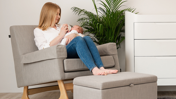 Gaia Baby Serena nursing and rocking chair in dove grey. Mother breastfeeding a baby while sitting on a rocking chair