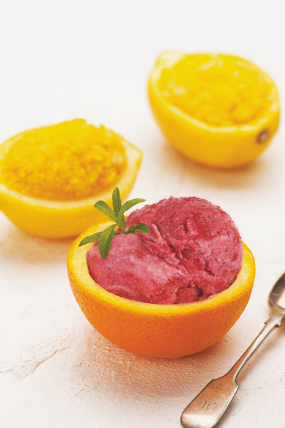 cranberry sorbet scooped in half a hollowed orange