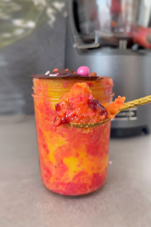 mango berry ice cream in jar with spoon closeup