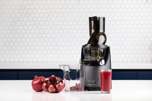 EVO820 juicer and a glass of pomegranate juice on a counter