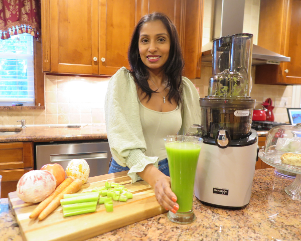 Shanna with a glass of celery juice and her Kuvings REVO830