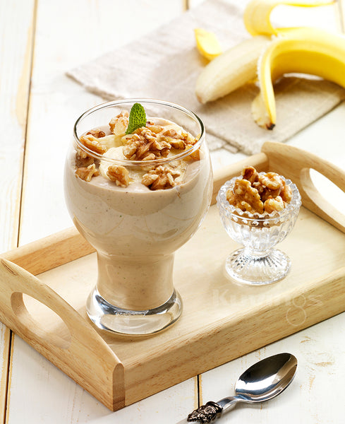 banana protein smoothie in glass with walnuts