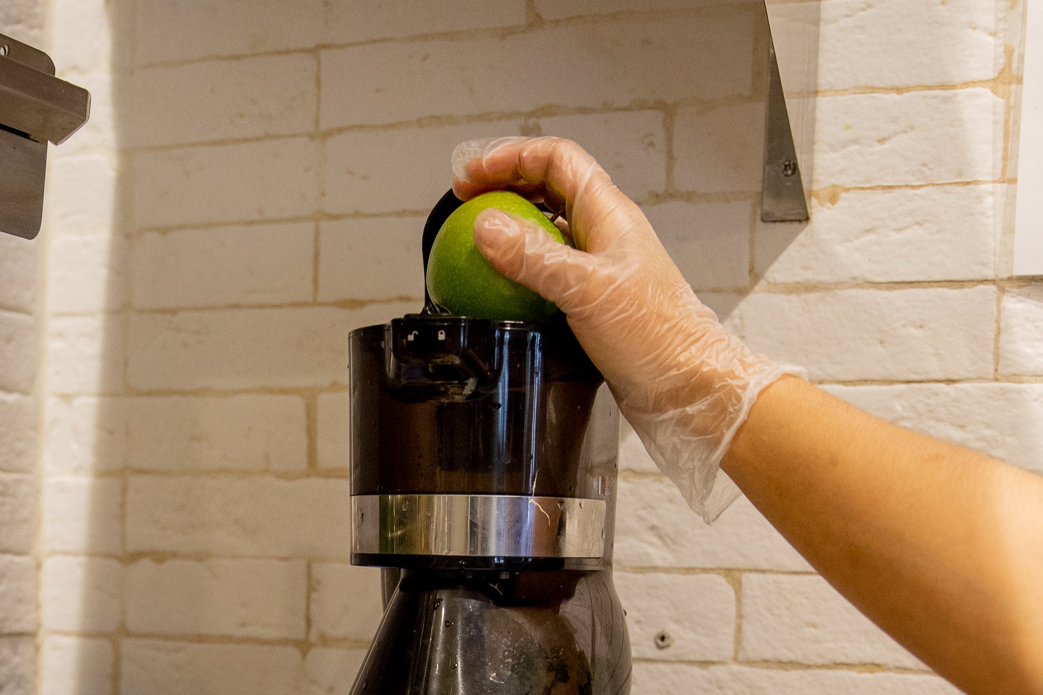 green apple going into juicer