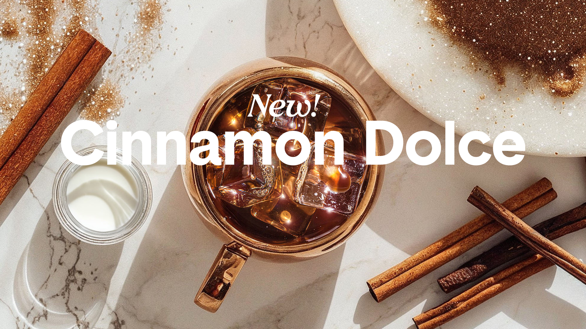 A promotional image for 'New! Cinnamon Dolce' featuring a drink with ice and cinnamon sticks.