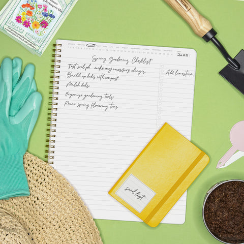 Gardening gloves, spade and seed packets with a Paperage planner listing all the garden tasks.