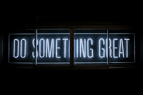 A neon sign letter saying "Do Something Great"