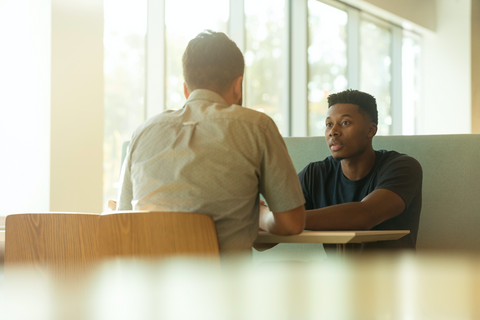 An image of two persons talking to each other