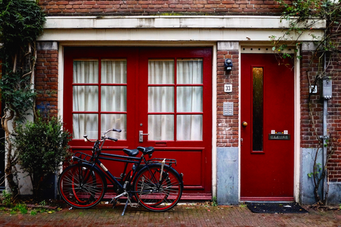 House with a red door, red windows and two bikes parked outside