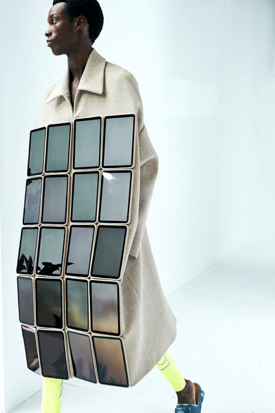 Model wears a coat covered in digital screens at Loewe's SS23 presentation for Paris Fashion Week