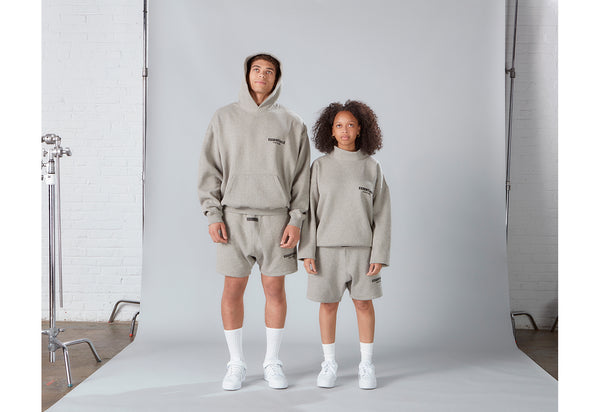 Male and female model wearing Fear of God Essentials Shorts and Hoodies