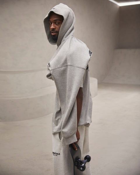 Model wears grey Fear of God hoodie, T-shirt and sweatpants