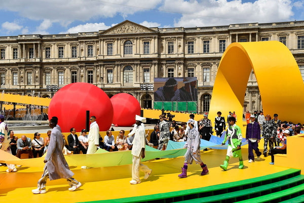 Models walk the runway outside the Louvre at Louis Vuitton's SS23 presentation for Paris Fashion Week