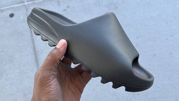 Yeezy Slide 'Onyx' held in hand