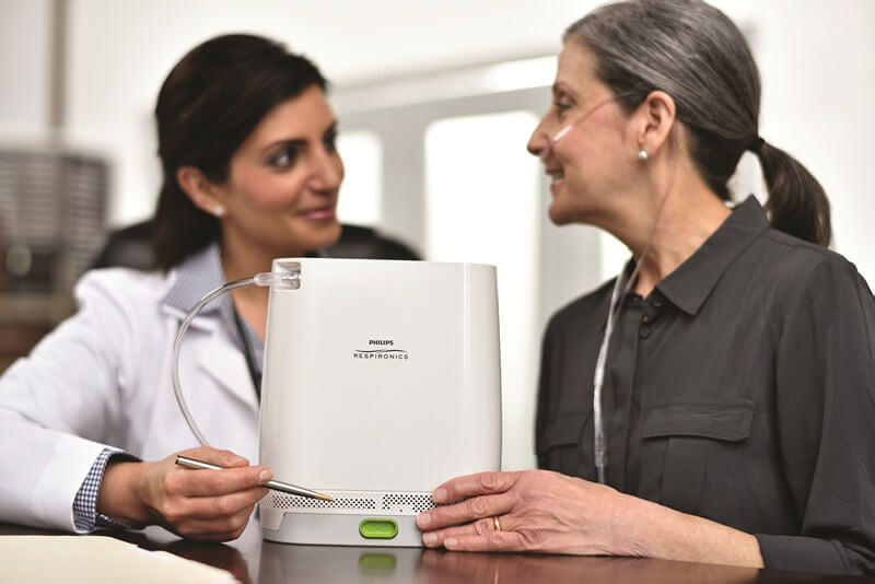A paitent using simply go mini portable oxygen concentrator  while sitting with doctor