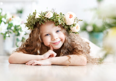 little girl laying down with flower crown on